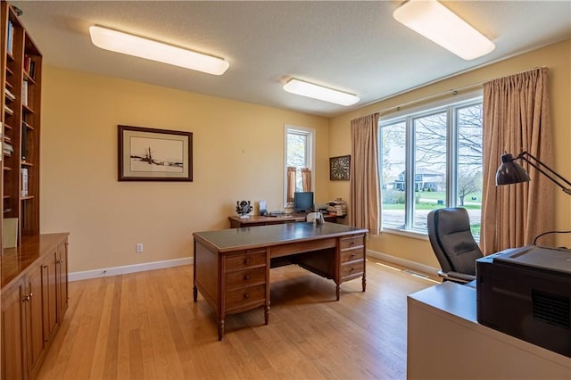 office space with light wood-style flooring and baseboards