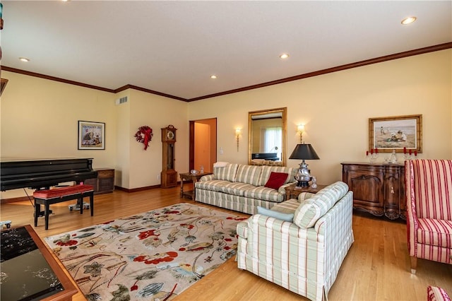 living room featuring wood finished floors, baseboards, ornamental molding, visible vents, and recessed lighting