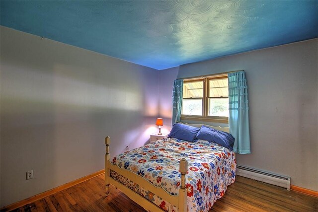 427 S Madison St, Cerro Gordo, IL 61818 - bedroom with baseboard heating, baseboards, and wood finished floors