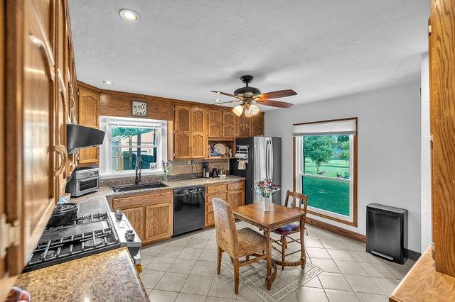 4170 N Taylor Ave, Decatur, IL 62526 - kitchen featuring black dishwasher, freestanding refrigerator, brown cabinets, plenty of natural light, and recessed lighting