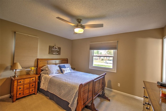 bedroom featuring light carpet, a textured ceiling, and ceiling fan