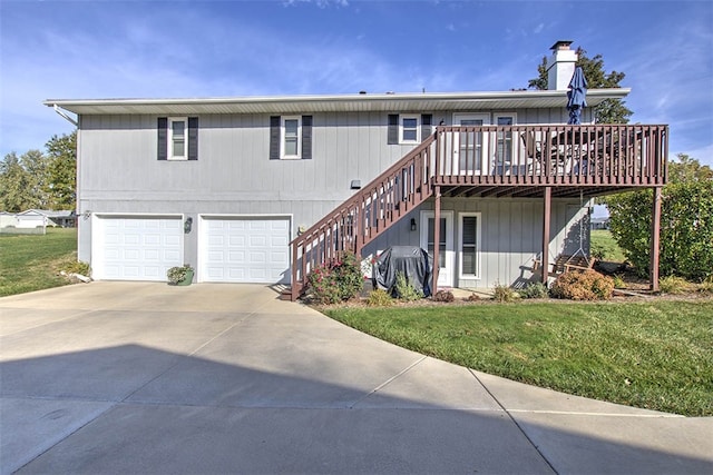 rear view of house with a garage, a deck, and a yard