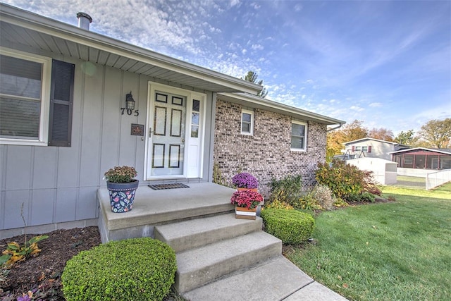 doorway to property featuring a lawn