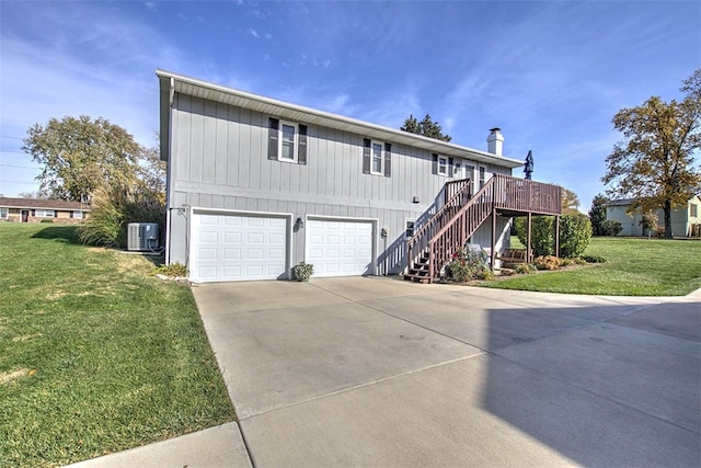 view of front of property with central air condition unit, a deck, a front yard, and a garage