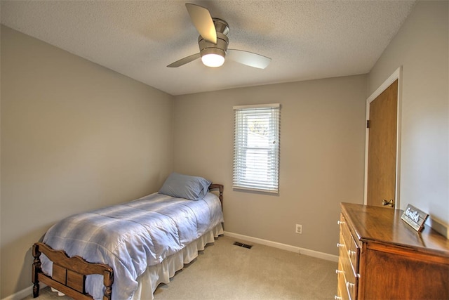 bedroom featuring a textured ceiling, ceiling fan, and light carpet