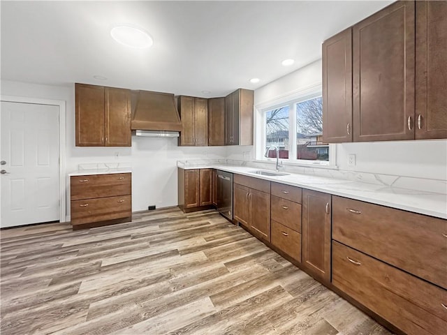 kitchen featuring light wood finished floors, dishwasher, recessed lighting, custom exhaust hood, and a sink