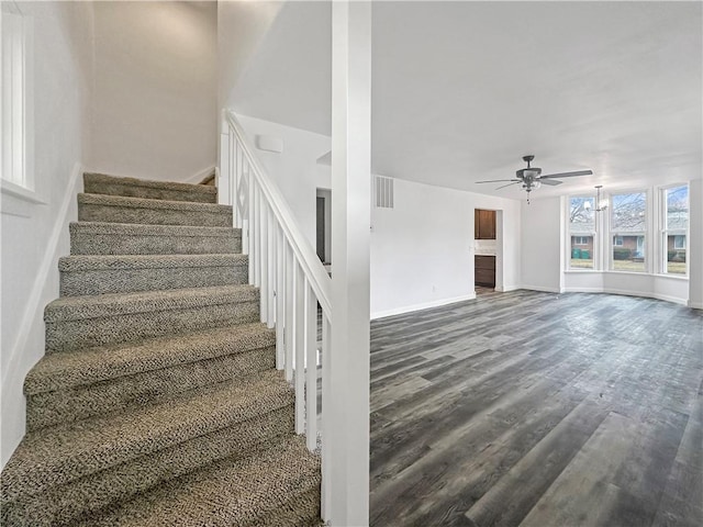 stairway featuring visible vents, baseboards, ceiling fan, and wood finished floors