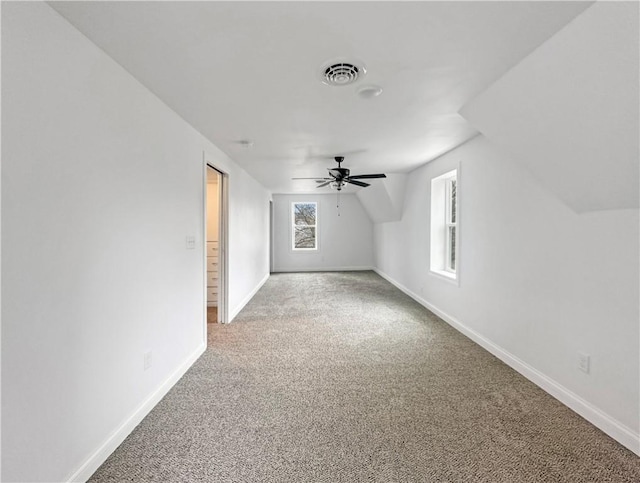 bonus room featuring visible vents, baseboards, light colored carpet, ceiling fan, and vaulted ceiling