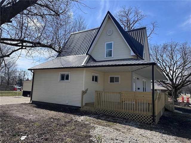 rear view of property featuring metal roof and a deck