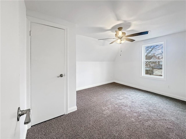 additional living space with dark carpet, baseboards, lofted ceiling, and ceiling fan