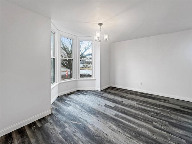 unfurnished dining area with dark wood-style floors, baseboards, and an inviting chandelier