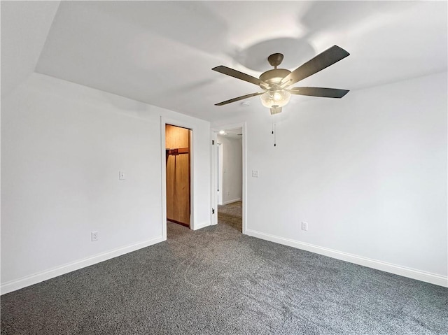 empty room with baseboards, a ceiling fan, and dark colored carpet