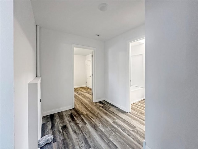 corridor with wood finished floors and baseboards