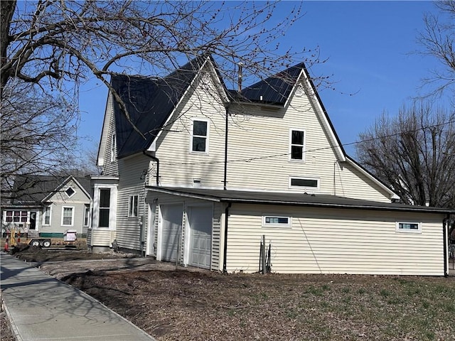 view of side of property with a garage and entry steps