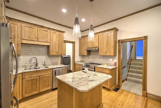 kitchen featuring appliances with stainless steel finishes, a sink, tasteful backsplash, under cabinet range hood, and ornamental molding