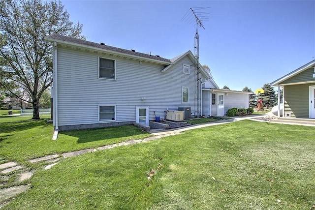 rear view of property with a lawn and central AC unit