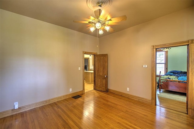 unfurnished bedroom with baseboards, a ceiling fan, light wood finished floors, and visible vents