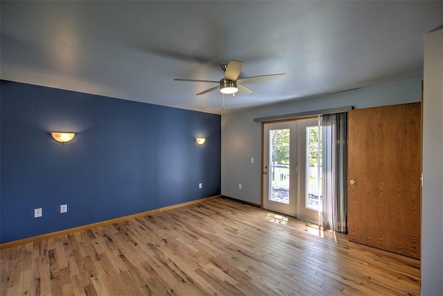 spare room with baseboards, a ceiling fan, and wood finished floors
