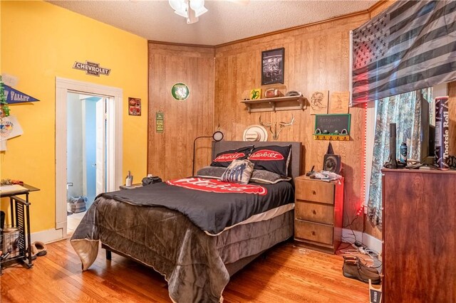 101 W N Water St, Bethany, IL 61914 - bedroom featuring wood walls, baseboards, wood finished floors, and a textured ceiling