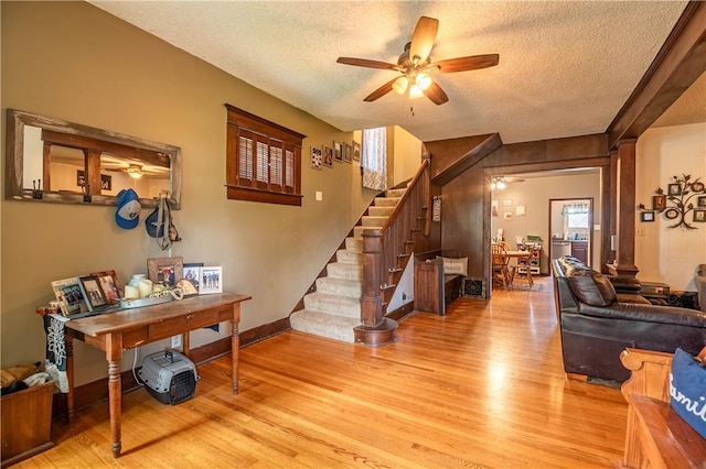 101 W N Water St, Bethany, IL 61914 - living area featuring a textured ceiling, light wood-type flooring, baseboards, a ceiling fan, and stairway