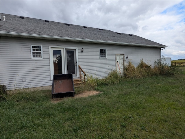 rear view of property featuring a yard