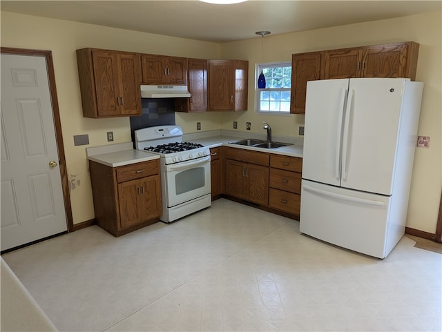 kitchen with sink, decorative light fixtures, and white appliances