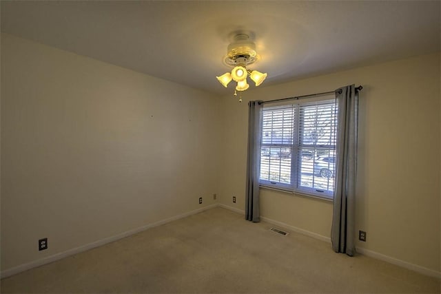 unfurnished room featuring visible vents, light colored carpet, and baseboards