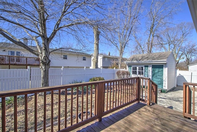 wooden deck featuring an outbuilding and a fenced backyard