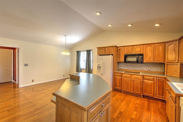 kitchen featuring brown cabinetry, lofted ceiling, black appliances, and wood finished floors