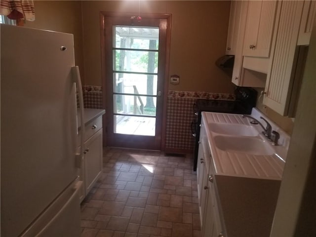 8404 E Twin Oaks Dr, Effingham, IL 62401 - kitchen with freestanding refrigerator, a sink, wainscoting, tile walls, and white cabinetry