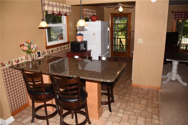 8404 E Twin Oaks Dr, Effingham, IL 62401 - kitchen featuring freestanding refrigerator, black microwave, a ceiling fan, a peninsula, and dark stone countertops