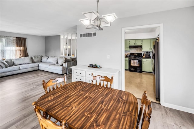 1450 W Westside Dr, Mt Zion, IL 62549 - dining room featuring a chandelier, light wood-style floors, and baseboards