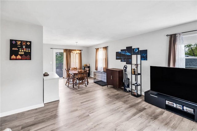 1450 W Westside Dr, Mt Zion, IL 62549 - living room with wood finished floors, a chandelier, and baseboards