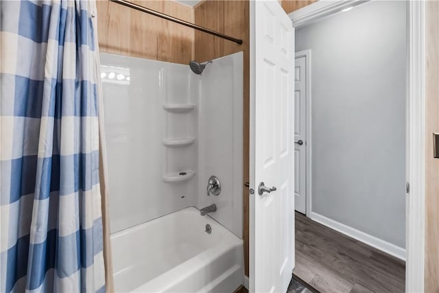 1450 W Westside Dr, Mt Zion, IL 62549 - full bathroom featuring wood finished floors, baseboards, and shower / bath combo with shower curtain