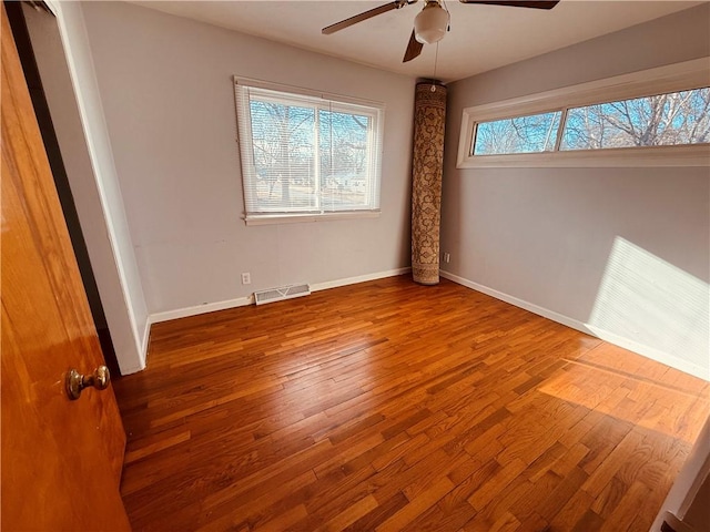 unfurnished bedroom with hardwood / wood-style flooring, baseboards, visible vents, and a ceiling fan