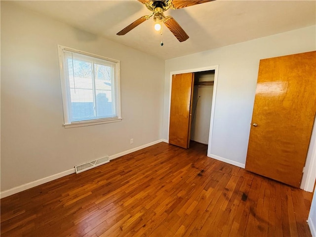 unfurnished bedroom featuring a ceiling fan, wood-type flooring, visible vents, and baseboards