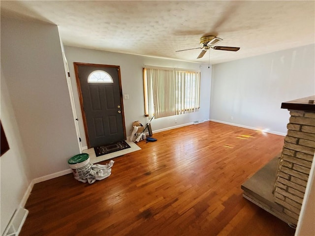 entryway featuring a ceiling fan, baseboards, and wood finished floors