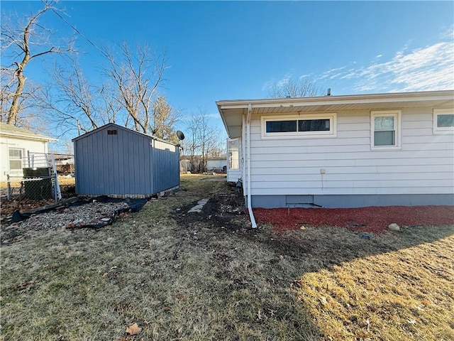 view of property exterior featuring a storage shed, fence, and an outdoor structure