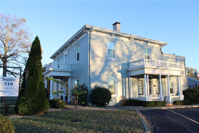 exterior space with a porch and a balcony