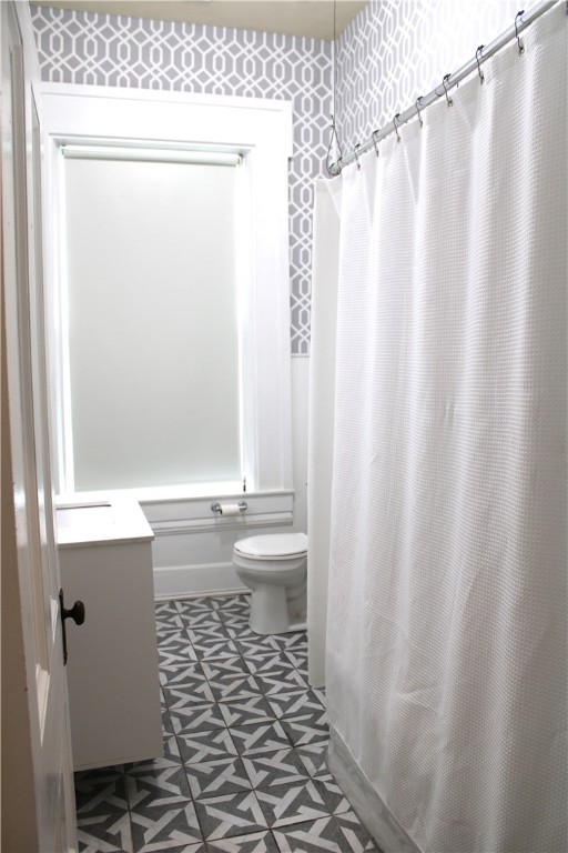 full bathroom with vanity, shower / bath combo, and toilet