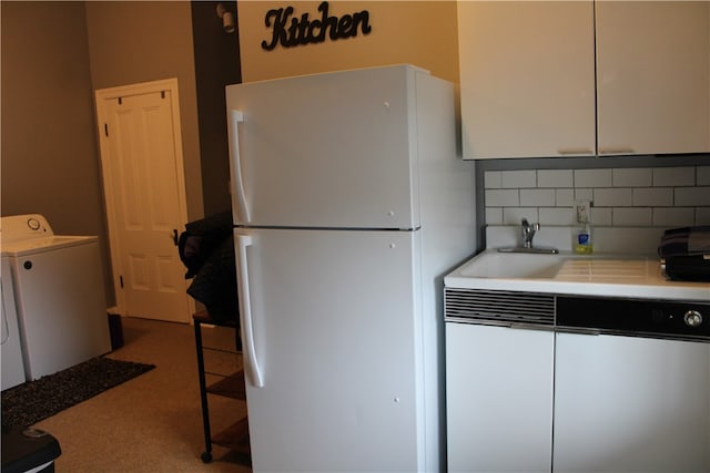 kitchen with tasteful backsplash, sink, white refrigerator, washer / clothes dryer, and white cabinetry