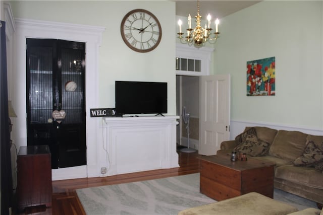 living room with hardwood / wood-style flooring and a notable chandelier