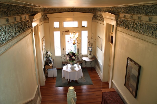 foyer featuring lofted ceiling, dark hardwood / wood-style flooring, and a notable chandelier