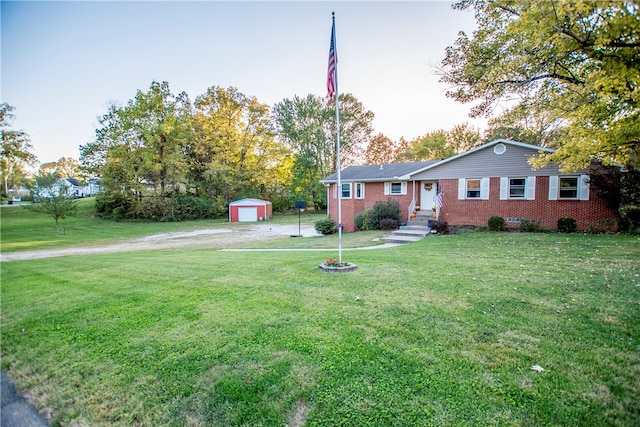 ranch-style home with a garage, an outbuilding, and a front lawn