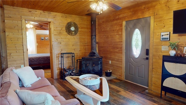 202 Eagle Blf, Oakwood, IL 61858 - living area featuring wooden walls, a ceiling fan, a wood stove, wood finished floors, and a wall mounted air conditioner