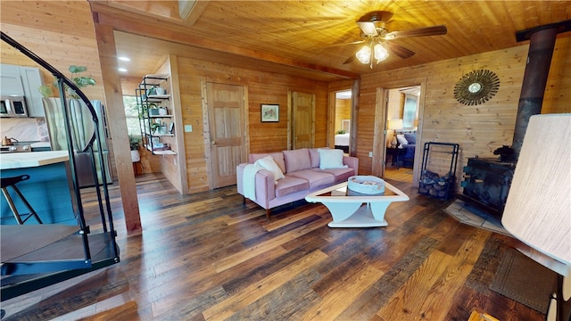 202 Eagle Blf, Oakwood, IL 61858 - living room featuring a wood stove, wooden walls, ceiling fan, wood ceiling, and dark wood finished floors