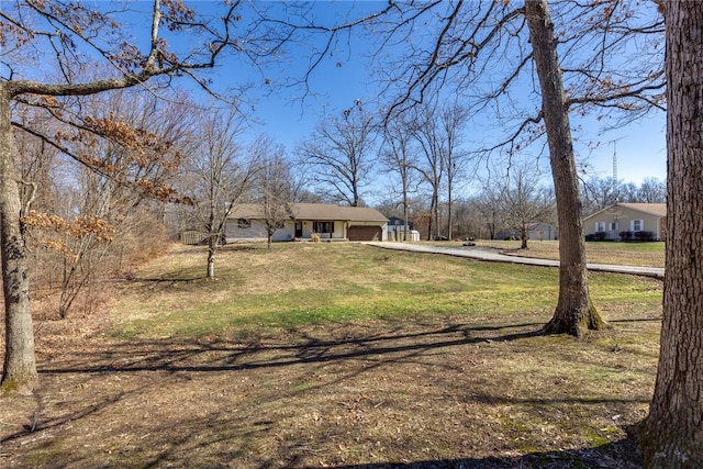 view of yard featuring driveway and a garage