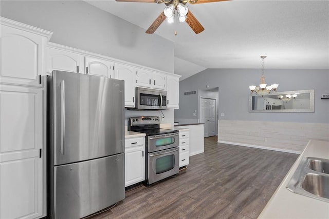 kitchen with white cabinets, stainless steel appliances, ceiling fan with notable chandelier, and lofted ceiling