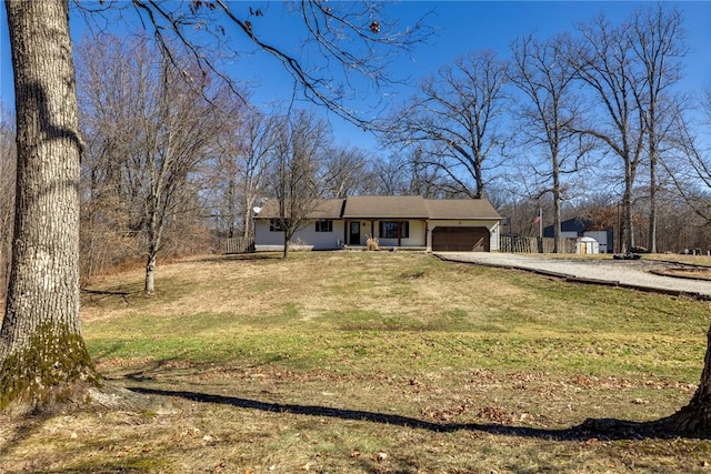 single story home featuring a front yard, driveway, and an attached garage
