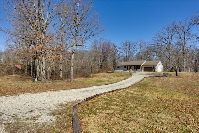 view of front of property featuring an attached garage, aphalt driveway, and a front lawn